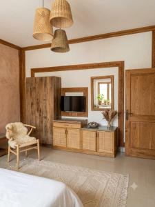 a bedroom with a tv and a chair and a mirror at Waves P'opin Resort in Mahabalipuram