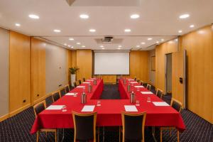 a conference room with a long table with red table cloth and chairs at City Life Hotel Poliziano, by R Collection Hotels in Milan
