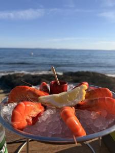 a plate of food with shrimp and carrots on the beach at La Villa Fafouille in Cavalaire-sur-Mer