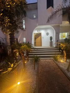 a building with stairs and a door with lights at Villa Triplex avec piscine proche de la mer in El Harhoura