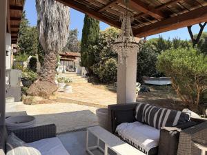 a patio with a couch under a pergola at La Villa Fafouille in Cavalaire-sur-Mer