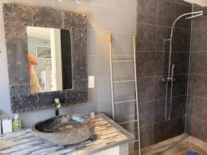 a person taking a picture of a bathroom with a sink at La Villa Fafouille in Cavalaire-sur-Mer