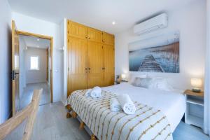 a bedroom with a large bed with towels on it at Apartment Julio Pomar, swimming pool in Sagres +27 photos