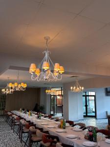 ein großes Esszimmer mit einem langen Tisch und Kronleuchtern in der Unterkunft Hotel Split in Glamoč