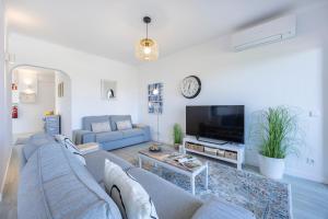 a living room with a couch and a tv at Apartment Julio Pomar, swimming pool in Sagres