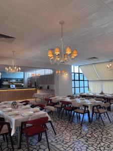 ein Esszimmer mit Tischen, Stühlen und Kronleuchtern in der Unterkunft Hotel Split in Glamoč