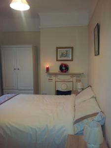 ein Schlafzimmer mit einem Bett und einem Tisch mit einer Lampe in der Unterkunft Town House in Ennis
