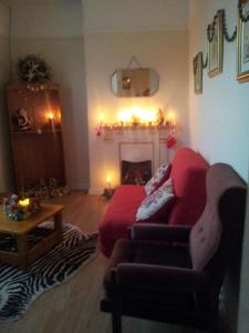 a living room with a red couch and a fireplace at Town House in Ennis