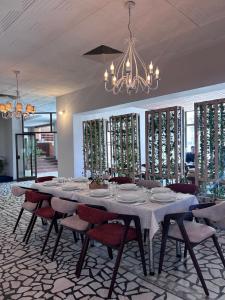 ein Esszimmer mit Tisch, Stühlen und Kronleuchter in der Unterkunft Hotel Split in Glamoč