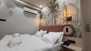 a bedroom with a white bed with a pink headboard at Shridhar inn in Alīganj +2 photos