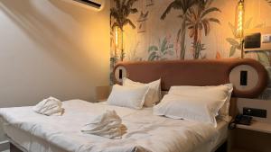 a bedroom with a bed with white sheets and pillows at Shridhar inn in Alīganj