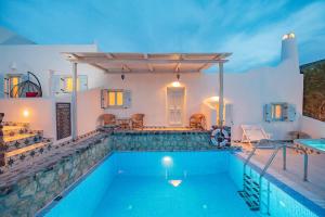 a villa with a swimming pool at night at Starlight Luxury Seaside Villa & Suites in Imerovigli +82 photos