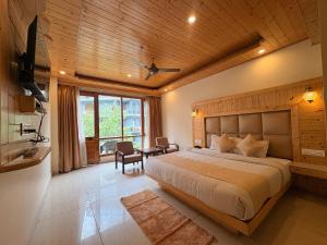 a bedroom with a large bed and a table and chairs at The Tanwar Villas in Manāli