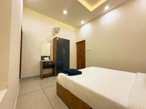 a bedroom with a bed and a cabinet and a mirror at La Dimora luxury pool villa in Vythiri