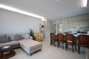 a living room with a couch and chairs and a kitchen at Avli Rooms in Himare