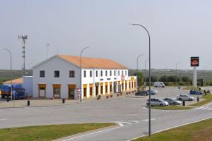 a large white building on the side of a road at AS Chucena in Chucena
