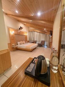 a hotel room with a bed and a tea kettle on a table at The Tanwar Villas in Manāli