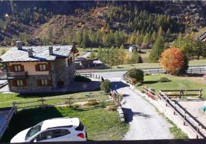 a white car parked in front of a house at Chalet a due passi piste da sci in Valgrisenche