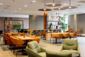 a restaurant with tables and chairs and a cafeteria at Scandic Stavanger Forus in Stavanger
