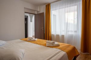 a bedroom with a bed with towels on it at Cabana Trei Brazi in Predeal