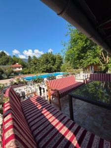 a patio with two red benches and a pool at Vila Noor Sarajevo in Sarajevo