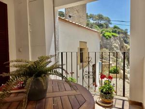 a room with a table and a balcony with a plant at EVH137 Can Biel in Tossa de Mar