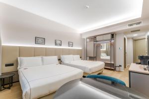 a hotel room with two beds and a sink at Acca Sporting Milano - AA Hotels in Opera +118 photos