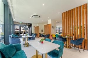 a dining room with blue chairs and tables at Acca Sporting Milano - AA Hotels in Opera
