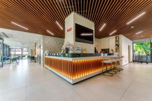 a lobby with a bar with yellow and orange at Acca Sporting Milano - AA Hotels in Opera
