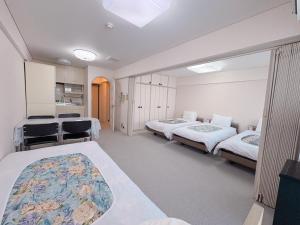 a large room with two beds and a kitchen at Weekly Green In Namba in Osaka