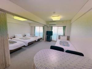 a hotel room with two beds and a tv at Weekly Green In Namba in Osaka
