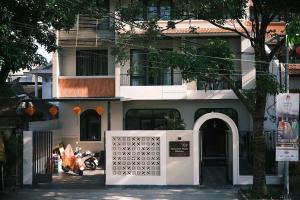 a white building with a gate in front of it at November House in Thôn Kim Long (1)