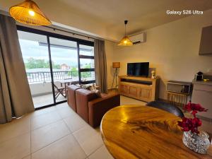 a living room with a couch and a table at Cozy Melody in Pirae