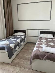 a bedroom with two twin beds and a window at Коттедж Атлантис in Balykchy