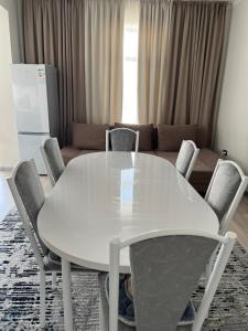 a white table and chairs in a living room at Коттедж Атлантис in Balykchy