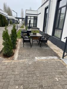 a patio with a table and chairs in front of a building at Коттедж Атлантис in Balykchy