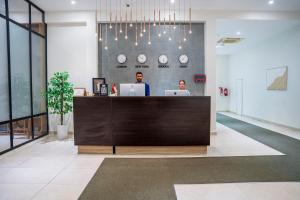 two people sitting at a reception desk in an office at Riviera Suites , Hotel Apartments in Sur