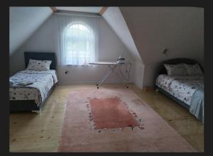 a attic room with two beds and a rug at Tinohovska vila in Hadžići