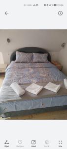 a bed with two sheets and two books on it at Tinohovska vila in Hadžići