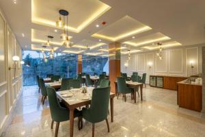a dining room with tables and green chairs at Kavin - The Chail Resort in Chail