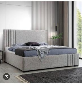 a large bed in a bedroom with a large window at JOHNOATCH APARTMENt in Ibasa
