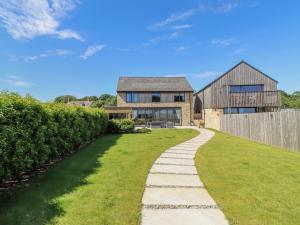 a stone path leading to a house with a barn at The Joiners Cottage in Morpeth