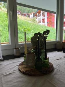 a table with a plate with plants and a window at Apollo in Saas-Fee
