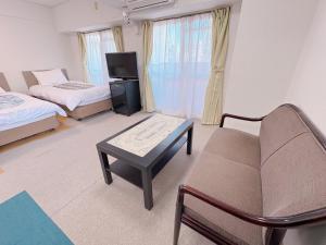 a room with two beds and a couch and a tv at Weekly Green In Namba in Osaka +36 photos