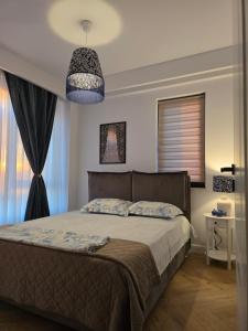 a bedroom with a bed and a pendant light at Cozy Central Home & Free Private Parking in Craiova