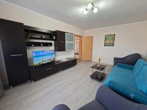 ein Wohnzimmer mit einer blauen Couch und einem Flachbildfernseher in der Unterkunft Riverside in Timişoara