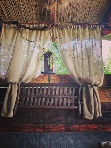 a window with curtains on top of a bench at Etno kuća Teodora in Staji°evo