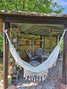 a hammock on a patio under a gazebo at Etno kuća Teodora in Staji°evo