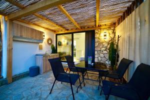 a patio with a table and chairs and a kitchen at Almond Beachfront Resort - kalyves Halkidiki in Kalives Poligirou