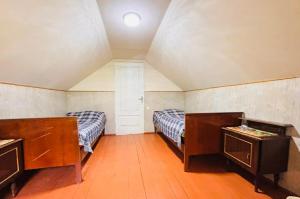 an attic room with two beds and a door at Villa Bubi in Tbisi